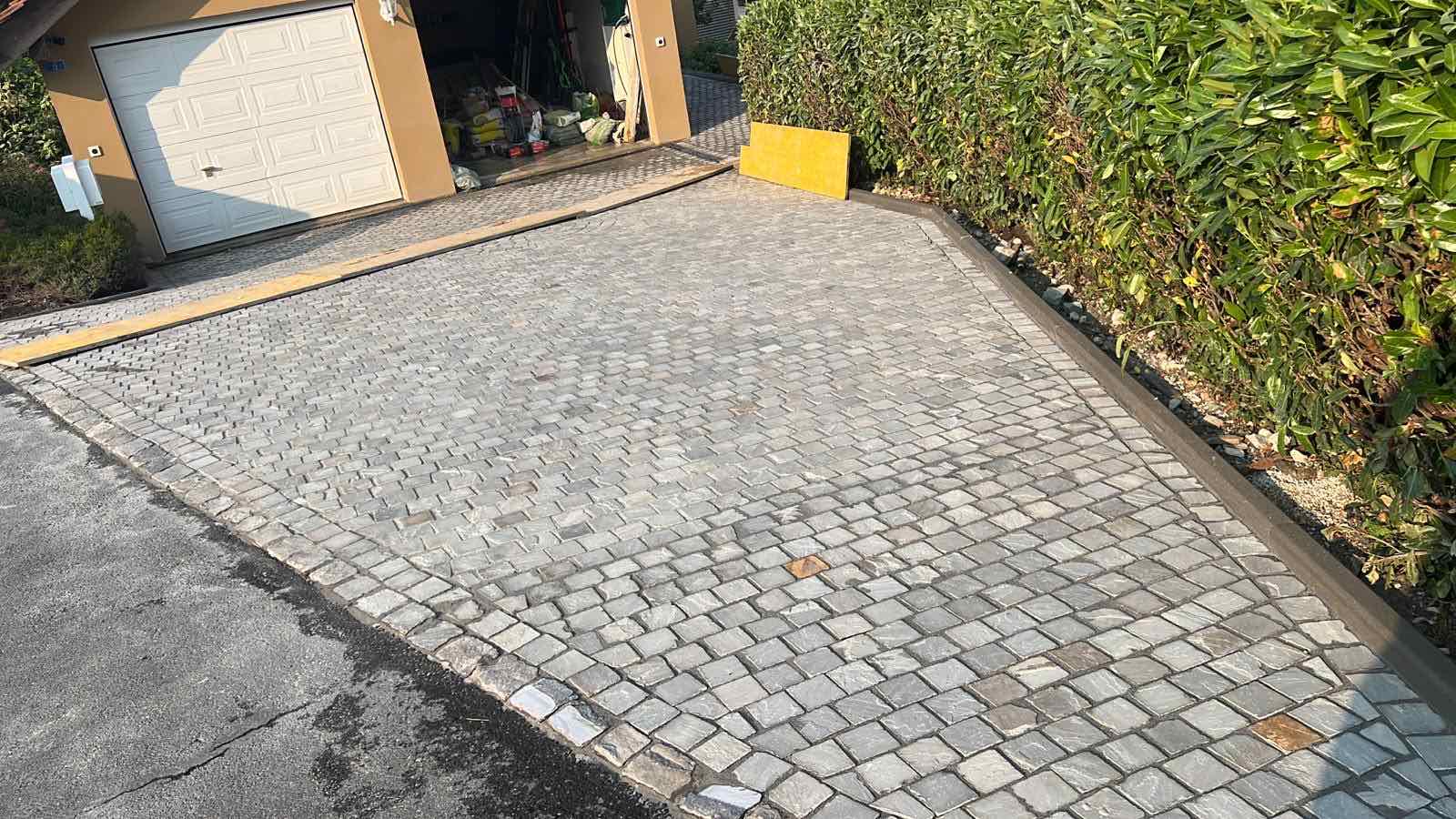 Allée de garage en pavés gris avec bordures soignées