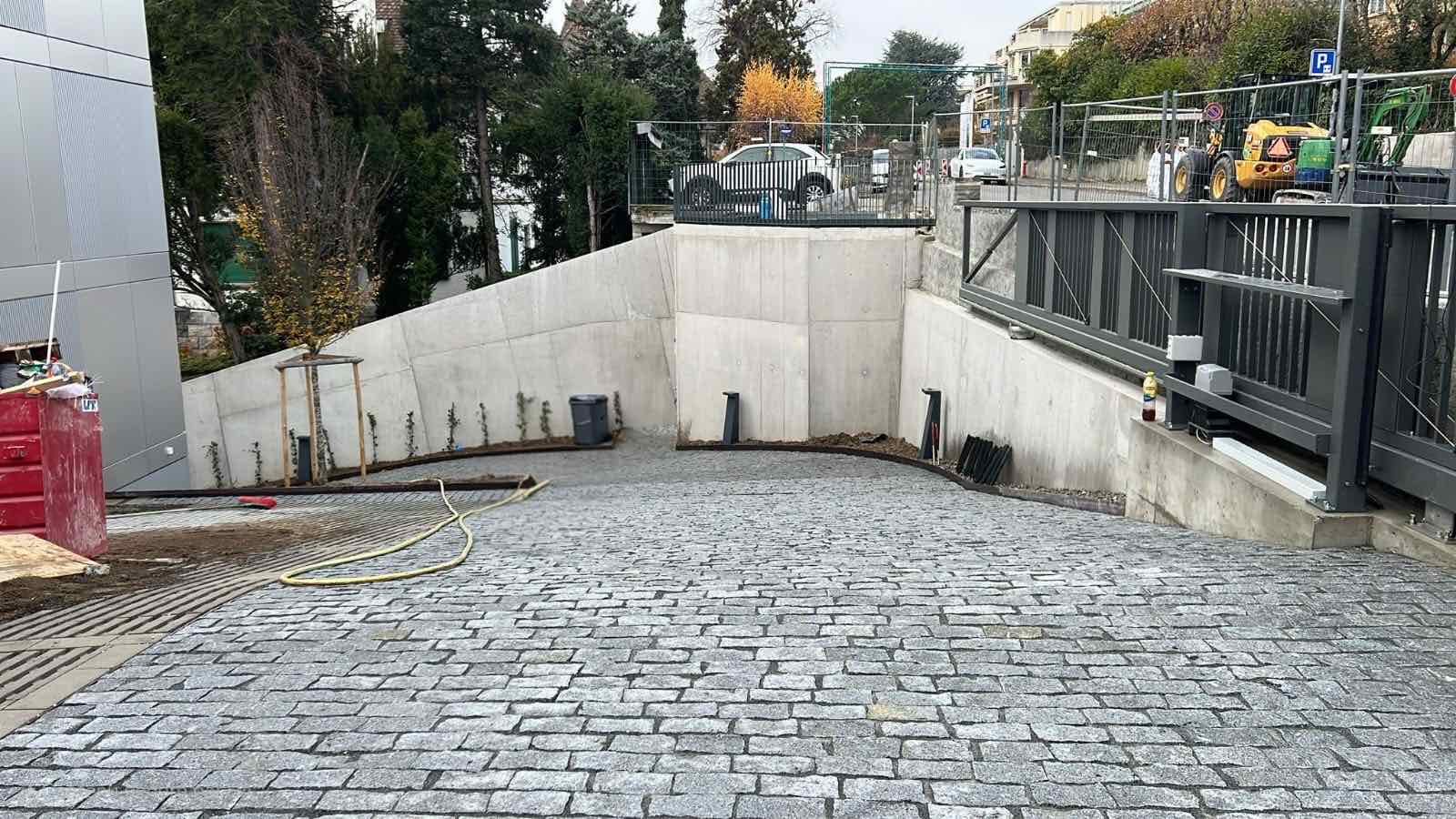 Rampe d'accès en pavés gris pour entrée carrossable